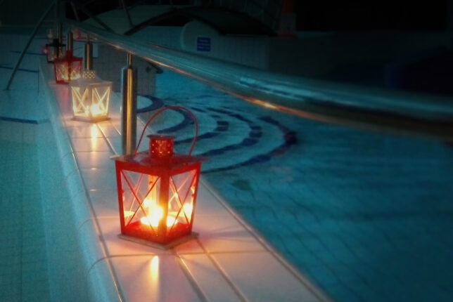 Kynttilälyhdyt tyhjän uima-altaan reunalla. Halli on suljettu.